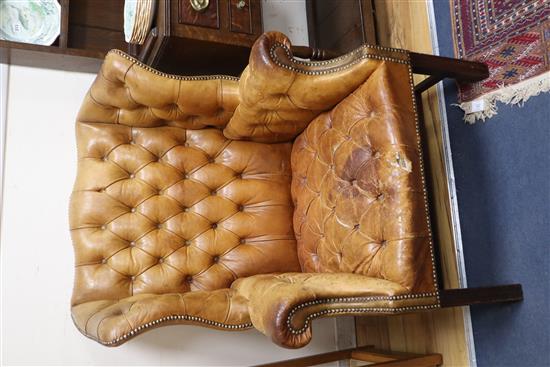 A pair of leather tan wing armchairs